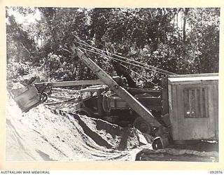 BOUGAINVILLE. 1945-05-31. A MOTOR SHOVEL OF 6 MECHANICAL EQUIPMENT COMPANY, ROYAL AUSTRALIAN ENGINEERS, SCOOPING UP SAND TO LOAD A THREE TONNER. THE SAND WILL BE USED FOR TOP DRESSING THE ..