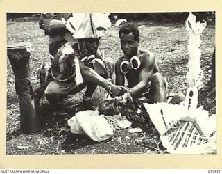 SONG RIVER, FINSCHHAFEN AREA, NEW GUINEA. 1944-03-26. BUKI BOYS PREPARING THEIR COSTUMES FOR A NATIVE SING-SING IN THE AUSTRALIAN NEW GUINEA ADMINISTRATIVE UNIT COMPOUND TO CELEBRATE THE RE ..