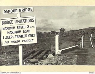 DUMPU, NEW GUINEA. 1944-02-03. THE DAMOUR SUSPENSION BRIDGE CROSSES THE FARIA RIVER BELOW THE 18TH INFANTRY BRIGADE AREA. THE BRIDGE WHICH SPANS 120 FEET AND MEASURES 6 FEET 2 INCHES BETWEEN KERBS ..