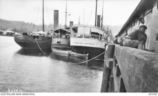 SIMPSON HARBOUR, NEW BRITAIN. HMAS PROTECTOR WITH TWO CAPTURED SHIPS, SUMATRA AND MADANG, AT RABAUL WHARF. THE SUMATRA WAS UTILISED AS AN OFFICERS' MESS AND THE MADANG FOR MOVING TROOPS ABOUT. ..