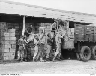 CAPE WOM, WEWAK AREA, NEW GUINEA, 1945-07-02. MEMBERS OF 2/22 SUPPLY DEPOT PLATOON LOADING RATIONS ON A FOOD STORAGE DEPOT TRUCK FOR TRANSPORT TO A STORES ISSUE DEPOT. THE UNIT HOLDS BULK SUPPLIES ..