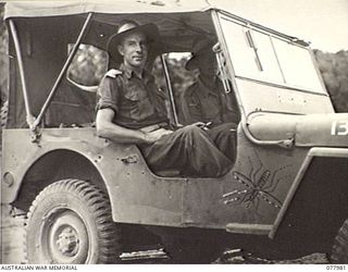 WUNUNG PLANTATION, NEW BRITAIN. 1944-12-30. SX6032 CAPTAIN J. S. GREENE, COMMANDING OFFICER (LEFT) AND NX90759 DRIVER N. HENZE IN THE JEEP "ATEBRIN" OF THE 28TH MALARIA CONTROL UNIT ATTACHED TO ..