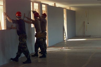 Members of 200th and 201st Red Horse Air National Guard, Rickenbacker Air National Guard Base, Columbus, Ohio, install wall board to create rooms for families in an old dorm at Andersen Air Force Base, Guam, to provide temporary housing for victims of Typhoon Paka