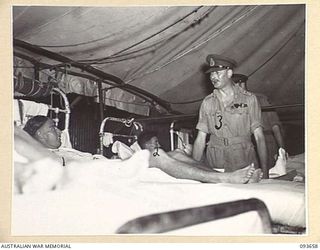 TOROKINA, BOUGAINVILLE, 1945-07-03. HIS ROYAL HIGHNESS, THE DUKE OF GLOUCESTER, GOVERNOR-GENERAL OF AUSTRALIA (3), SPEAKING TO A PATIENT DURING HIS INSPECTION OF 2/1 GENERAL HOSPITAL. IDENTIFIED ..