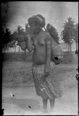 Woman wearing a grass skirt and a bilum, Papua, ca. 1923 / Sarah Chinnery
