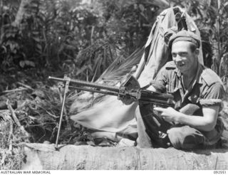 BOUGAINVILLE. 1945-05-24. PRIVATE G. H. BURNETT, A MEMBER OF A PATROL FROM D COMPANY, 26 INFANTRY BATTALION (AUSTRALIAN IMPERIAL FORCE), HOLDS A TYPE 91 6.5 MM LIGHT MACHINE-GUN TAKEN FROM A ..