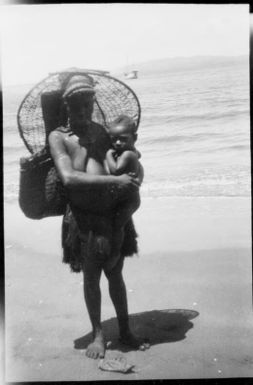 Woman with a fishing basket on her back and holding an infant, Awar, Sepik River, New Guinea, 1935, 2 / Sarah Chinnery