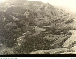 RAMU VALLEY, NEW GUINEA. 1944-06-18. LOOKING DOWN ON GUY'S POST FROM THE APPROACH TO SHAGGY RIDGE. A PATROL FROM 11TH DIVISION CARRIER COMPANY IS ACCOMPANYING LIEUTENANT R. B. EWER, OFFICIAL WAR ..