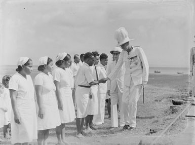 [Men in military uniform addressing Pacific island women and men]