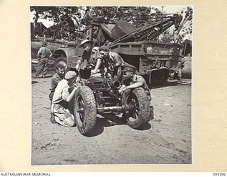 DALLMAN, WEWAK AREA, NEW GUINEA. 1945-08-28. PERSONNEL OF LIGHT AID DETACHMENT, ATTACHED 2/1 TANK ATTACK REGIMENT ROYAL AUSTRALIAN ARTILLERY, EXAMINING ONE OF OUR 75 MM HOWITZER MOUNTAIN GUNS. ..