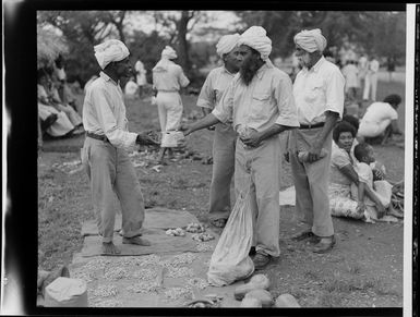 Unidentified Fijian Indian buying produce off another, market at Ba, Fiji