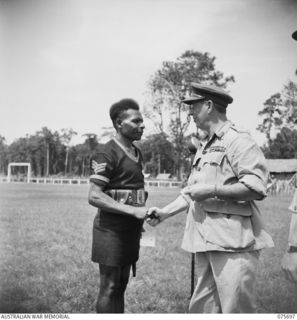 LAE, NEW GUINEA. 1944-09-09. VX13 LIEUTENANT-COLONEL S.G. SAVIGE, CB,CBE, DSO, MC, ED, GOC, NEW GUINEA FORCE (1) CONGRATULATING 1879 SERGEANT IWAGU, ROYAL PAPUAN CONSTABULARY WITH THE GEORGE MEDAL ..