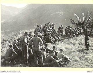 YAULA, NEW GUINEA. 1944-04-08. VX104114 CHAPLAIN G.T. SAMBELL (1), CONDUCTING THE EASTER SUNDAY SERVICE ON A MOUNTAIN TOP OVERLOOKING BOGADJIM WITH MEMBERS OF C COMPANY HEADQUARTERS, 57/60TH ..