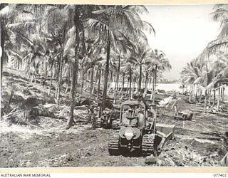 PALMALMAL PLANTATION, NEW BRITAIN. 1944-11-29. PERSONNEL OF THE 2/3RD RAILWAY CONSTRUCTION COMPANY, 48TH DEPUTY COMMANDER ROYAL ENGINEERS (WORKS) USING HEAVY EARTH MOVING EQUIPMENT TO BUILD A ROAD ..