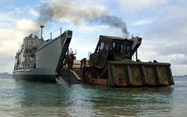 Beach MASTER 3 Brandon Schieber, Beach MASTER Unit 1, directs a Cat D-7 Dozer onto Landing Craft, Utility (LCU) 1634 in Inner Apra Harbor, Guam in support of Exercise TANDEM THRUST 2003