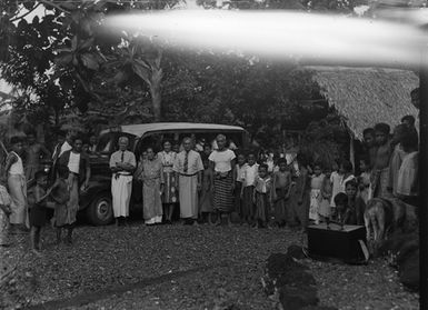 [A group of Pacific islanders standing outside]