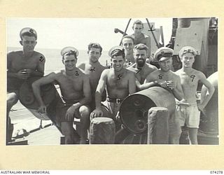 AT SEA. 1944-06-24. ROYAL AUSTRALIAN NAVY PERSONNEL GROUPED AROUND A "Y" GUN (USED FOR CATAPAULTING DEPTH CHARGES) ABOARD THE FAIRMILE ML431 (MOTOR LAUNCH) AS THE VESSEL PATROLS ALONG THE COAST ..