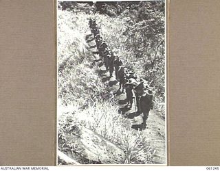 KUMBARUM, NEW GUINEA. 1943-11-30. TROOPS OF D COMPANY, 2/31ST AUSTRALIAN INFANTRY BATTALION, RETURNING FROM THE FORWARD AREAS IN THE FINISTERRE RANGES