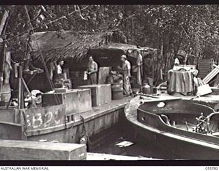 MOROBE, NEW GUINEA. 1943-08-13. UNITED STATES SMALL SHIPS SECTION, TUCKED AWAY IN THEIR DAYTIME HIDEOUT. LEFT TO RIGHT:- SERGEANT BENSON, MESS SERGEANT; CHIEF ENGINEER JAMES MCGLONE, HEAVY ..