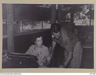 LAE, NEW GUINEA. 1945-05-15. SERGEANT L. TEAGUE (1), WORKING FOR THE DEPUTY DIRECTOR OF MEDICAL SERVICES, HEADQUARTERS FIRST ARMY, RECEIVES INSTRUCTION IN HER NEW JOB FROM SERGEANT D.M. GORDON (2). ..