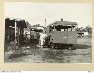 LAE, NEW GUINEA. 1944-05-24. VX36796 PRIVATE C.R. WILSON (1), AT THE 2/7TH GENERAL HOSPITAL ASSISTING THE LOADING OF WILES STEAM COOKERS. THESE TWO MOBILE UNITS HANDLE DELIVERY TO THE 200 WARDS ..