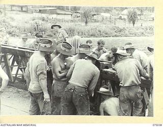 LAE, NEW GUINEA. 1944-08-09. TROOPS OF THE 20TH FIELD COMPANY, JOINING THE TWO SECTIONS OF STEEL BOX GIRDER BRIDGE WHICH THE UNIT IS BUILDING ACROSS THE BUTIBUM RIVER TO REPLACE THE ONE WHICH WAS ..