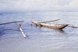 French Polynesia, children swimming by canoes off Moorea Island