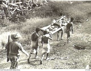 YAULA, NEW GUINEA. 1944-04-10. VX108664 CORPORAL E. ANTHERSON, 57/60TH INFANTRY BATTALION (1), BEING CARRIED BY NATIVE STRETCHER BEARERS TO THE NEAREST ADVANCED DRESSING STATION AT SAIPA NO. 1