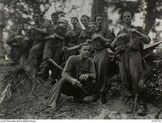 Pearl Ridge, Bougainville. 1945-03-07. Unidentified members of a reconnaissance patrol from the Far Eastern Liaison Office (FELO) relaxing with a cup of tea outside a Young Men's Christain ..