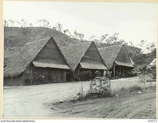 SEVENTEEN MILE, PORT MORESBY, PAPUA, NEW GUINEA, 1944-03-01. THE THREE HUTS THAT CONSTITUTE THE SISTERS' MESS AT THE 2/9TH AUSTRALIAN GENERAL HOSPITAL. THE MESS IS A COMBINATION OF KITCHEN, DINING ..