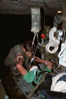 Sergeant (SGT) Shawn Fawell, a member of the 68th Medical Detachment at Hickam Air Force Base, reassures a patient prior to transport to Queens Hospital