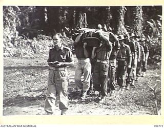 SORAKEN, BOUGAINVILLE, 1945-09-17. CHAPLAIN E.V. CONSTABLE LEADING PALL BEARERS TO GRAVESIDE FOR THE BURIAL OF SAPPER R.C. KENNON, KILLED IN ACTION ON BOUGAINVILLE. THE REMAINS RECOVERED BY MEMBERS ..