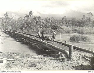 BABIANG ROAD, AITAPE AREA, NEW GUINEA. 1944-12-04. ENGINEERS OF NO. 9 PLATOON, 2/8TH FIELD COMPANY, BUILDING A COCONUT LOG BRIDGE ACROSS A STREAM ON THE AITAPE-DOGRETO ROAD