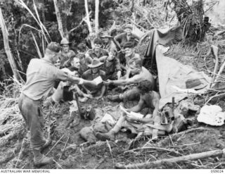 FARIA VALLEY, NEW GUINEA, 1943-10-17. MAIL BEING HANDED OUT TO TROOPS OF "A" COMPANY, 2/16TH AUSTRALIAN INFANTRY BATTALION ON JOHN'S KNOLL. SHOWN: QX131732 CORPORAL N.C.R. POOLE (1); VX109872 ..