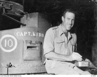 1942-12-28. PAPUA. CAPT. N.G. WHITEHEAD WHO LED THE TANK ATTACK ON THE JAPANESE POSITIONS AT BUNA. HE IS SITTING ON HIS TANK WHICH HAS BEEN NAMED "CAPTAIN KIDD." ONE OTHER TANK WAS NAMED "CAPTAIN ..