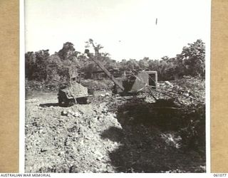 FINSCHHAFEN AREA, NEW GUINEA. 1943-11-04. A POWER SCOOP OF THE 2/3RD AUSTRALIAN FIELD COMPANY, ROYAL AUSTRALIAN ENGINEERS, AT WORK NEAR THE QUOJA RIVER ON THE NEW ROAD BETWEEN SCARLET BEACH AND ..