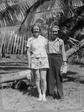 [Portrait of two people in front of a palm tree]