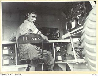 KATIKA, NEW GUINEA. 1944-03-31. NX65187 SIGNALMAN C. STRAHAN, B AUSTRALIAN CORPS SIGNALS, AT THE TRANSMITTING KEY OF THE 188F (UNITED STATES ARMY 191F), WIRELESS TRANSMITTER-RECEIVER. WHEN NOT IN ..