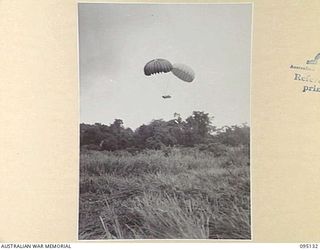 KIARIVU, NEW GUINEA, 1945-08-09. OF HIGH PRIORITY, 75MM GUNS ARE DROPPED TO 2/7 INFANTRY BATTALION WITH TWO PARACHUTES TO ENSURE THEIR SAFE ARRIVAL TO THE DROPPING ZONE