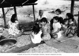 Rongelap women cooking while children play, summer 1964