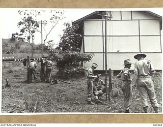 SOGERI, NEW GUINEA. 1943-11-20. STUDENTS OF THE SCHOOL OF SIGNALS, NEW GUINEA FORCE PRACTISING DIFFERENT METHODS OF WIRING ON THE PRACTICE LINES ERECTED AT THE SCHOOL. SHOWN ARE: NX120423 SIGNALMAN ..