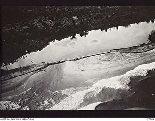 TUJU RIVER AREA, BOUGAINVILLE ISLAND. 1945-07-28. PHOTOGRAPH TAKEN BY NO. 5 SQUADRON, RAAF, OF THE BRIDGE OVER THE TUJU RIVER, CONSTRUCTED BY ROYAL AUSTRALIAN ENGINEERS. NOTE REVETMENTS TO PREVENT ..