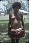 Adolescent girl wears colorful short fiber skirt and shell necklace