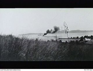 Port Moresby, Papua, 1942-02-28. Smoke rises from a RAAF Consolidated Catalina aircraft, burning at its mooring in Port Moresby harbour after being hit by a bomb during a Japanese air raid. (Donor ..