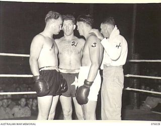 MADANG, NEW GUINEA. 1944-09-16. BOXERS BEING INTRODUCED TO THE AUDIENCE FROM THE RING AT THE 165TH GENERAL TRANSPORT COMPANY DURING THE BOXING AND WRESTLING TOURNAMENT BETWEEN MEMBERS OF THE RAN, ..