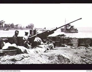 LAE, NEW GUINEA. 1943-10-04. A BOFORS GUN OF "D" BATTERY, 102ND COAST ARTILLERY BATTALION, ANTI-AIRCRAFT, UNITED STATES ARMY, WITH CAMOUFLAGE REMOVED AND THREE GUNNERS. THIS GUN IS SITUATED ON THE ..