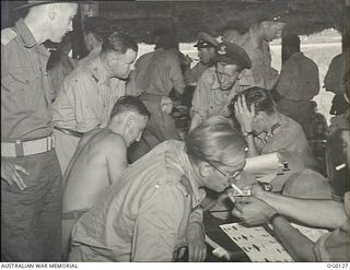 VIVIGANI, GOODENOUGH ISLAND, PAPUA NEW GUINEA. 1943-10-12. CREWS OF NO. 30 (BEAUFIGHTER) SQUADRON RAAF BEING DEBRIEFED ON RETURN FROM THE DAYLIGHT RAID ON RABAUL