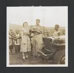 Joan Carne and Ronald Carne, holding a puppy, with others beside a motor vehicle, Papua New Guinea, 1947