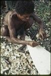 Canoe-building: man carves nipawa (grasshopper) design on prow