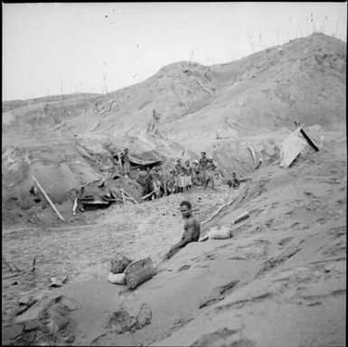 Papuan men digging out their village houses after the eruption, Rabaul, New Guinea, 1937, 2 / Sarah Chinnery
